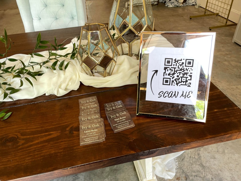 Right side of welcome table with Ivy and Oak wedding venue business cards.