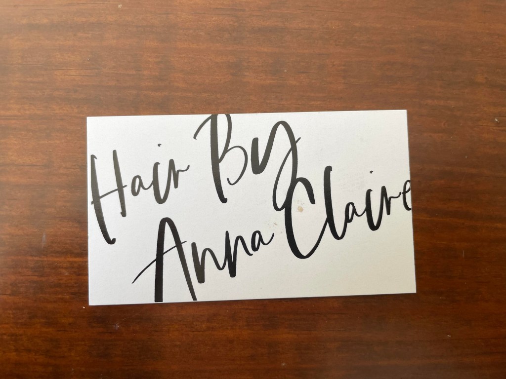 The front of the business card for Hair By Anna Claire